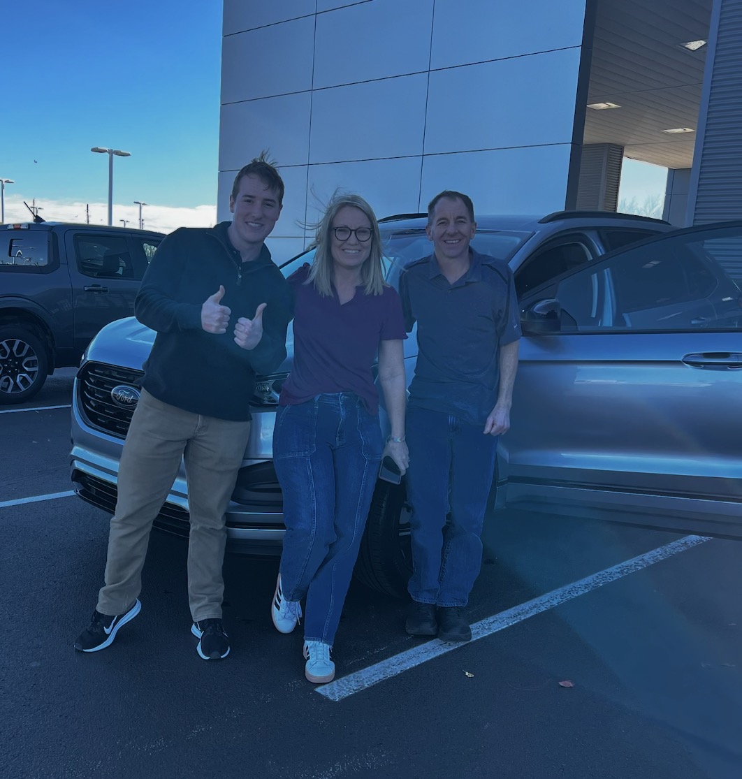Family taking delivery of a Ford Edge at the dealership