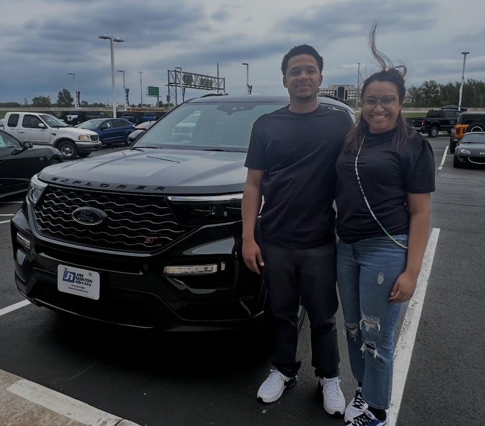 Couple taking delivery of a black Ford Explorer ST