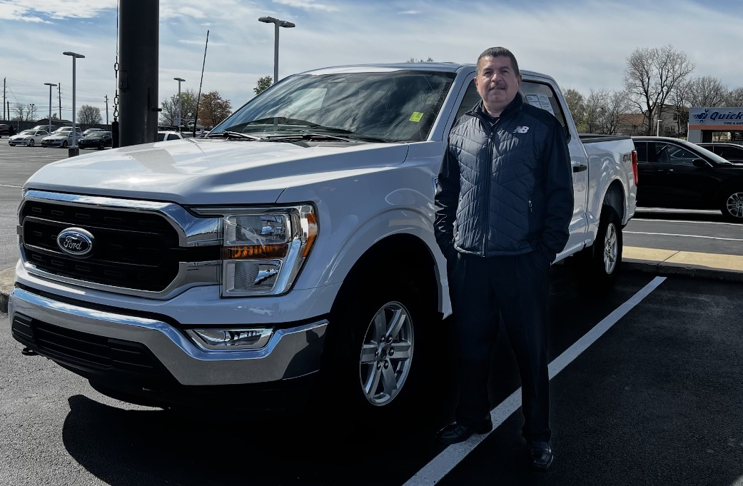 Customer taking delivery of a white Ford F-150 pickup