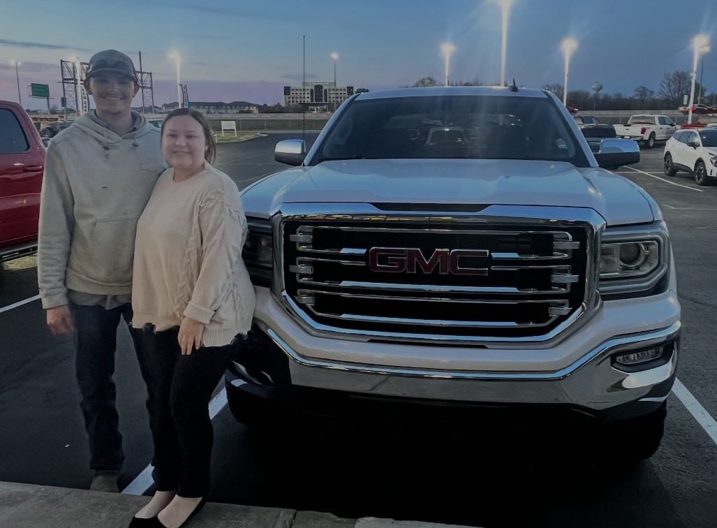 Couple in front of a white truck at dusk on delivery day
